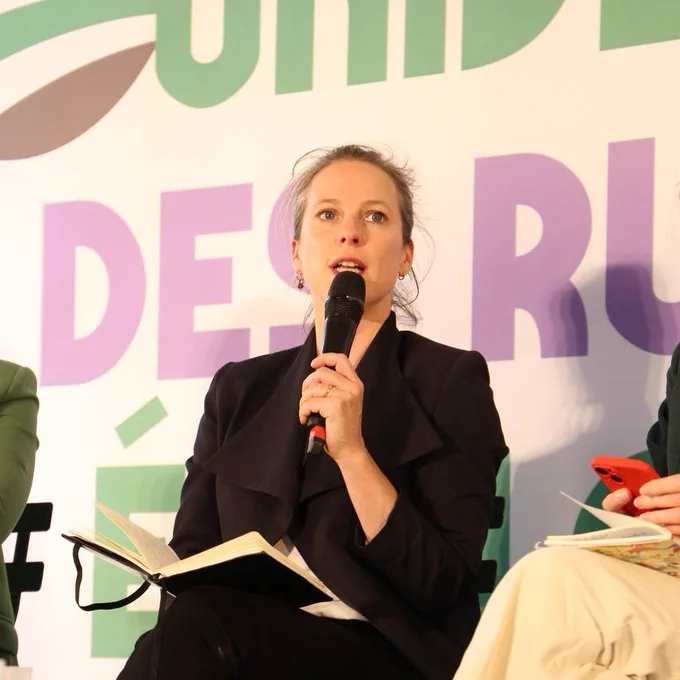 Lucie Castets assise, un micro à la main