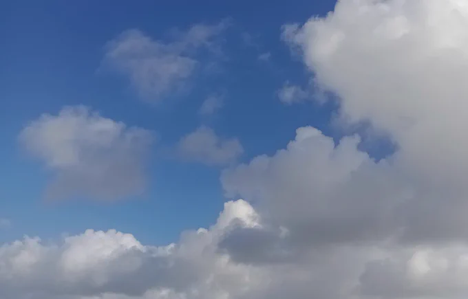 Random white and light grey clouds in a blue sky