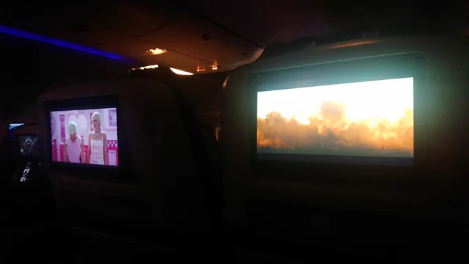 the same view, a little later into the films; barbie on the left (and ken is also there). simultaneously an atomic fireball fills the screen to the right, at the site of the first test at the trinity site. the contrast is visually fun, with several tones of pink filling the entire left screen in various ways, versus the violence unleashed with nuclear fire