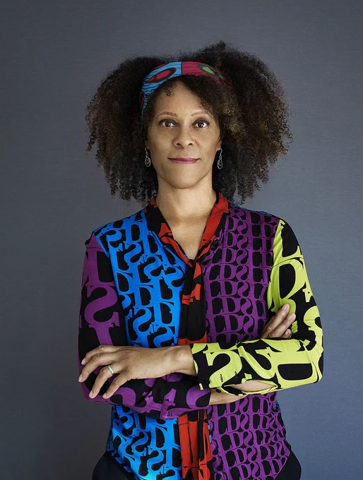 Headshot of Bernardine Evaristo – she wears a brightly coloured shirt and headband