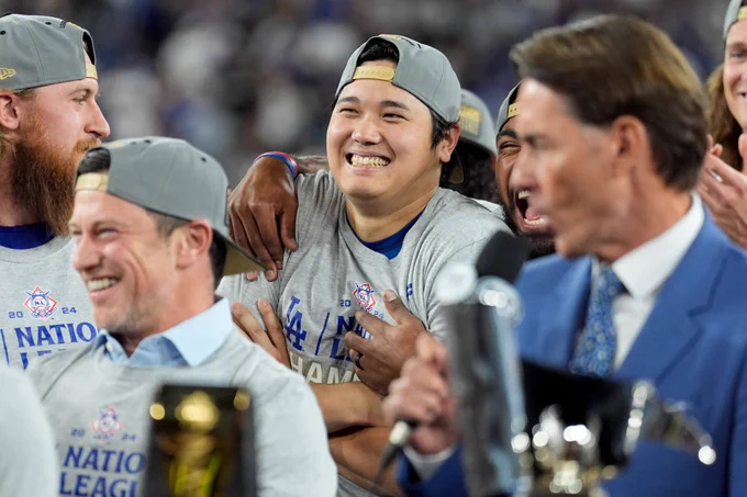 Shohei Ohtani smiles while celebrating the Dodgers capturing a World Series berth on Sunday night. 