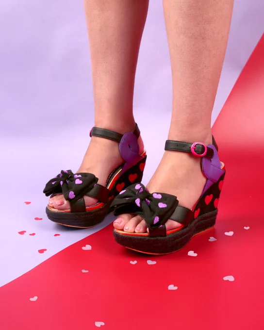 Irregular Choice 'Rinse N Repeat' black wedges. Purple and red heart details.