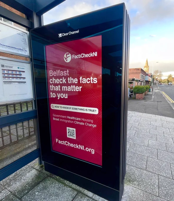 Red factcheckni billboard at bus stop