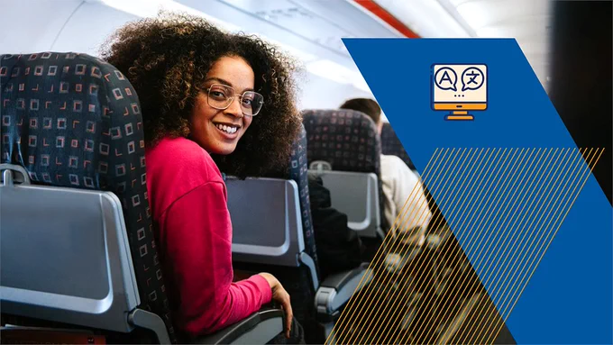 A woman on an airplane smiling at the camera.