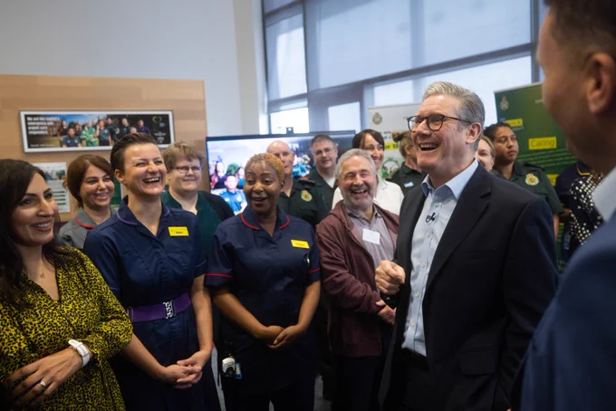 Prime Minister Keir Starmer and Secretary of Health and Social Care, Wes Streeting laughing with staff at the London Ambulance Service Dockside Centre.