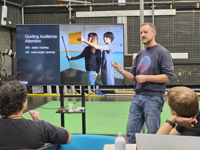 A man stands up in front of a screen to give a talk