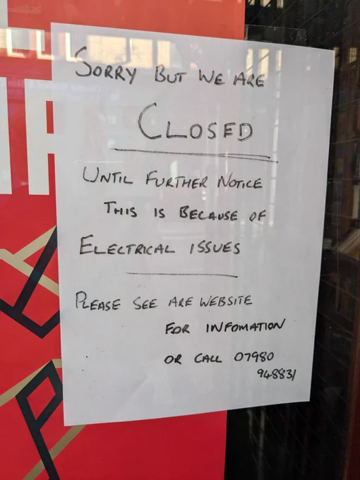 A sign on the bookshop window reading "Sorry but we are Closed Until Further Notice This is because of Electrical issues Please see are [sic] website for infomation [sic] or call 07980 948831"
