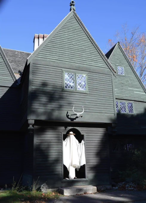 A figure wearing a ghost costume standing in the doorway of an 17th century house at Saugus Iron Works National Historic Site.