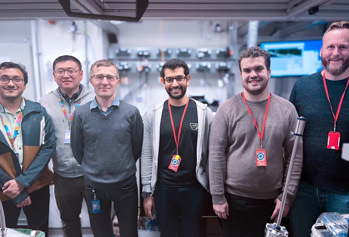 CLF and Liverpool scientists stand smiling in front of Ultra laser