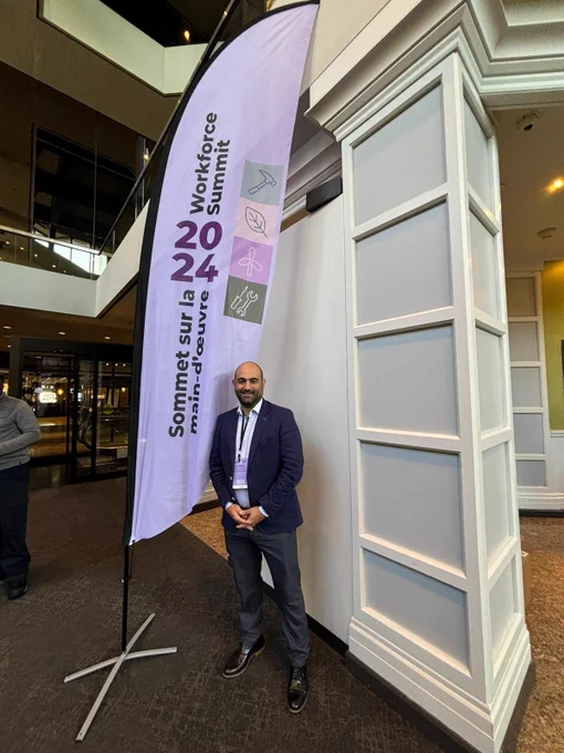 Mark DeMontis standing in front of 2024 Workforce Summit flag 