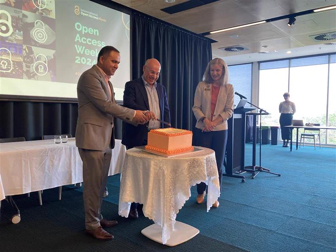 Prashant Pandey and Vincent Bulone cutting the open access week cake as Liz Walkley Hall watches.