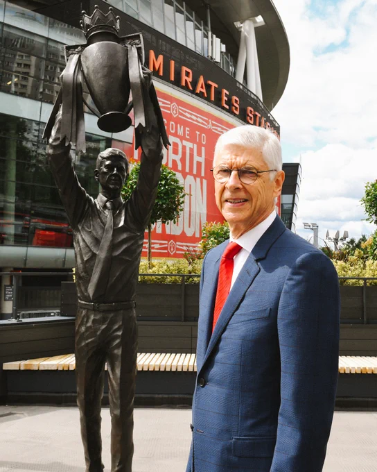 He later poses in front of his statue.