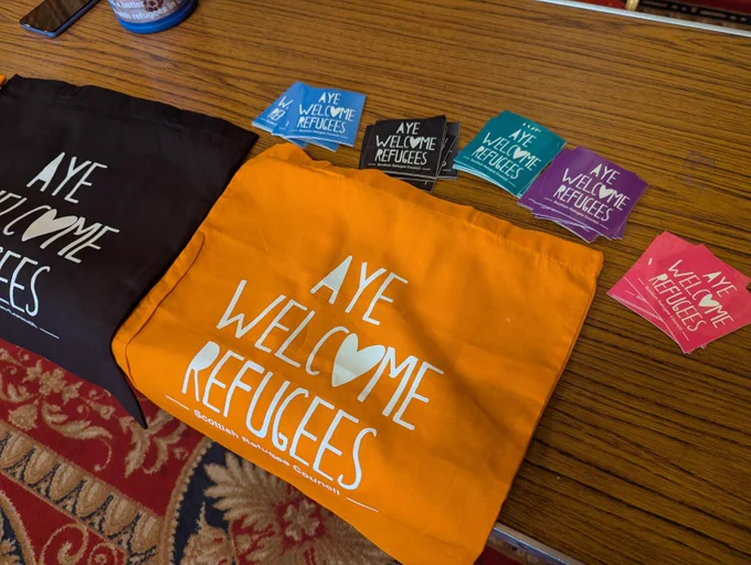 A collection of Scottish Refugee Council 'Aye Welcome Refugees' merchandise