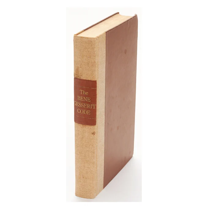 A brown, hardbound book with the title “The Bene Gesserit Code” featured in the spine”