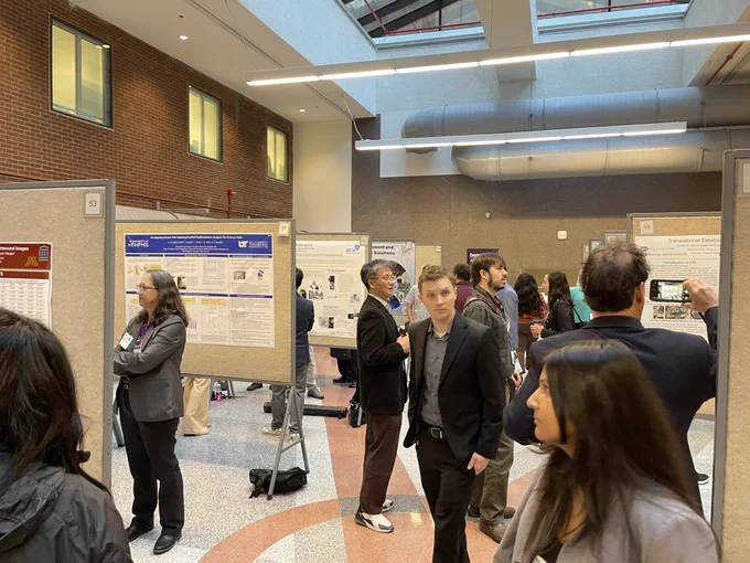 A photograph of scientific posters and their presenters at an NIH event