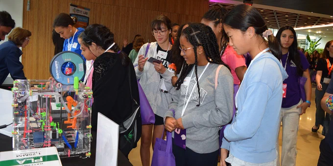 Students standing around a booth at the Amazon Web Services Girls' Tech Day.