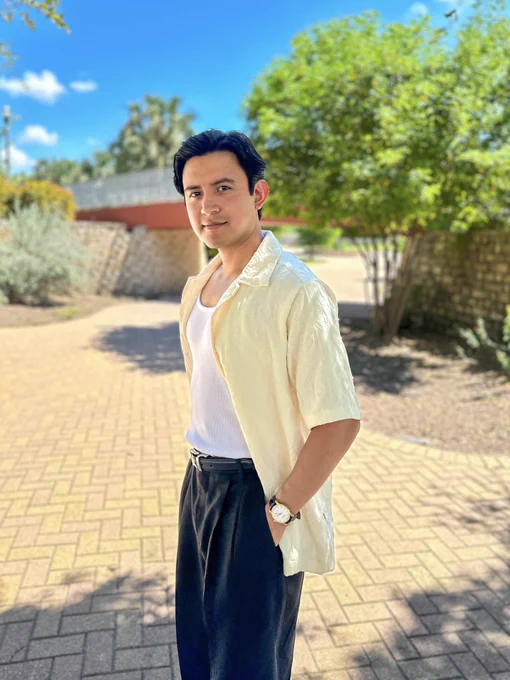 Joe Steven wearing white shirt with black pants walking through nature park.