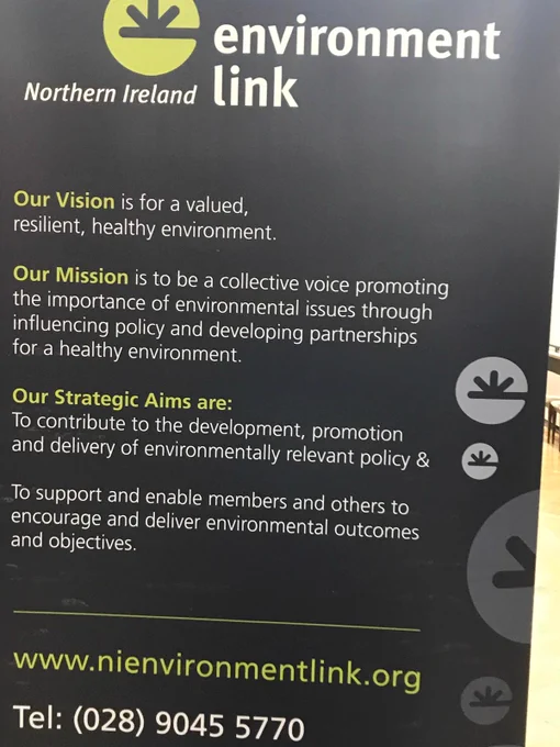 Photo of NIEL pop up screen - black with white and lime text. Text reads: "Northern Ireland Environment Link. Our Vision is for a valued, resilient, healthy environment. Our Mission is to be a collective voice promoting the importance of environmental issues through influencing policy and developling partnerships for a healthy environment. Our Strategic Aims are: To contribute to the development, promotion and delviery of environmentally relevant policy & To support and enable members and others to encourage and deliver environmental outcomes and objectives.  www.nienvironmentlink.org Tel: (028) 9045 5770
