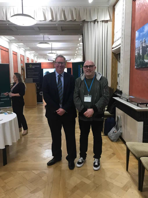 Photo of NIEL @environmentNI CEO Max Bryant with Peter Fleming of @theWeatherbies, smiling to camera in a room at Stormont.
