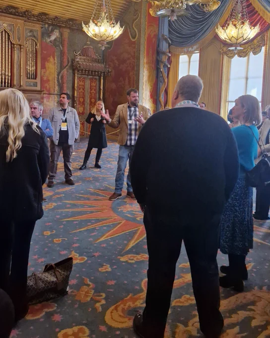 A group of delegates with Dan Cox in the Music Room at the Royal Pavilion