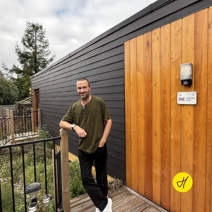 Hopestead Place resident Lewis Paterson in front of the ‘pod’ where he currently lives