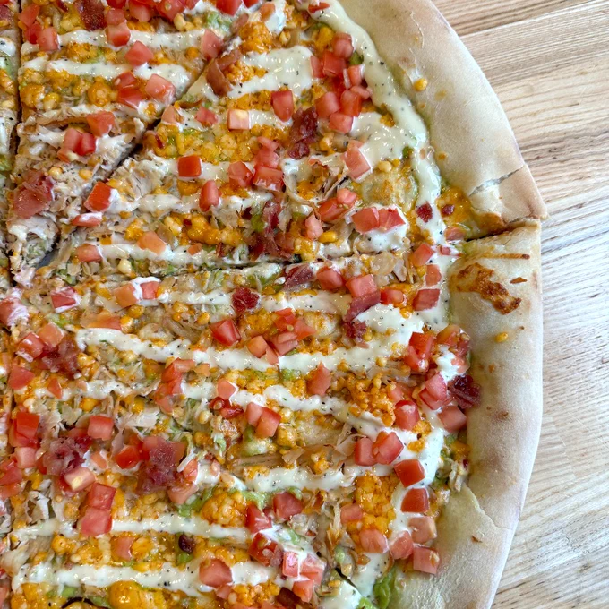 A close up of the right side of the Turket Roast Ghost. A description of the Turkey Roast Ghost: mozzarella, avocado creme, turkey, bacon, ghost pepper cheese, topped with ranch and diced tomatoes