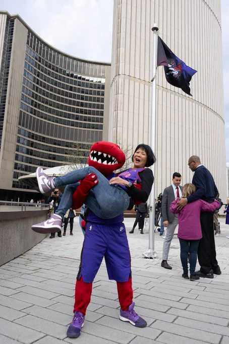 Mayor Olivia Chow is picked up by The Raptor, the Toronto Raptors’ mascot.