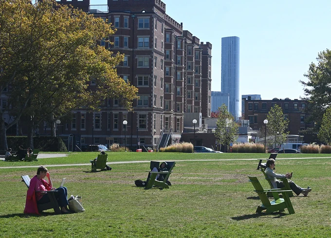 Students sitting in lawn chairs studying outside.
