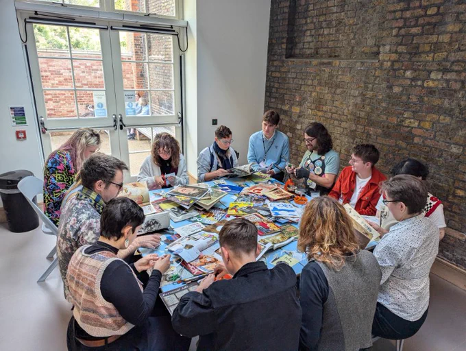 People gathered around a table enjoying a badge-making crafting activity