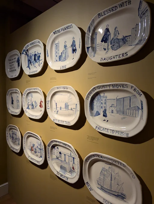 Ceramic plates on a museum wall telling the story of Gustavus Guydickens