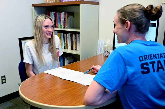 The head of the advising office meets with a student. 