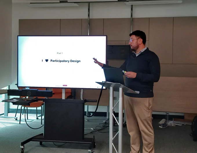  Fernando giving a talk with a slide that says: I heart Participatory Design. 