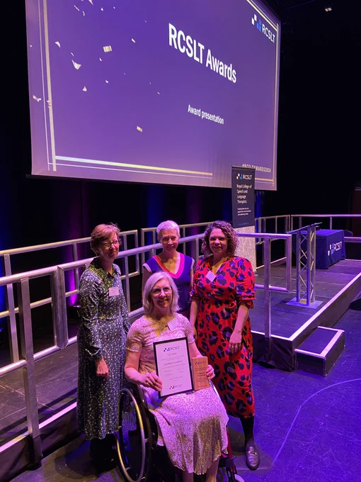 Professor Lucy Henry seated with award alongside 3 colleagues