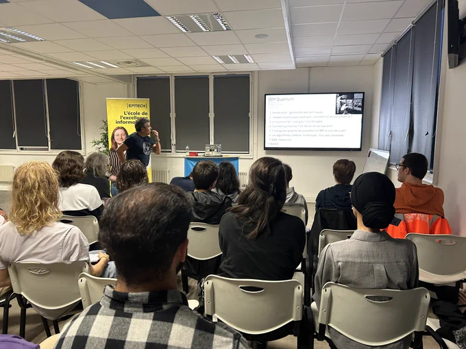 Un speaker regardant sa slide projeté à l’arrière de la salle,
Devant lui une vingtaine de personne assise l’écoutant.