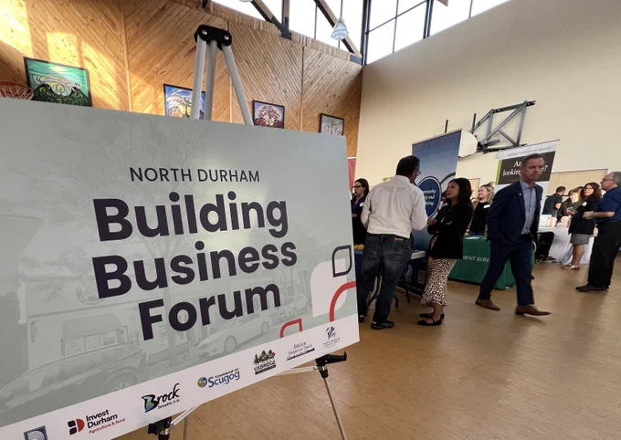 Sign on left reads North Durham Building Business Forum with people standing and talking on the right
