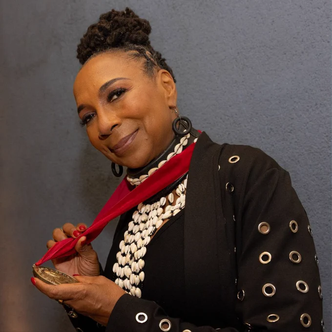 Kimberlé W. Crenshaw posing with a smile, holding the W.E.B. Du Bois Medal.