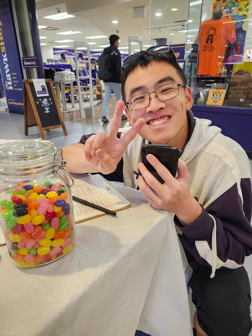 Photo of a student smiling and giving a peace sign.
