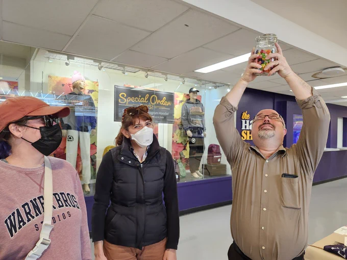 Photo of three WLUFA Members. One is holding a jar of jellybeans over their head.