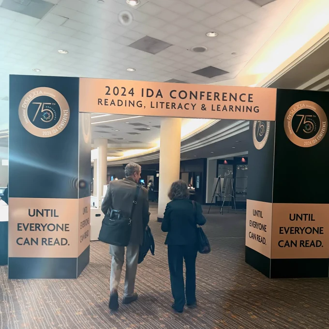 Dr. David Hurford and Dr. Linda Siegel walk through the entrance to the 2024 IDA Reading, Literacy, and Learning conference.