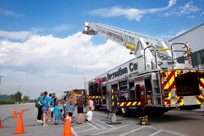 A volunteer firefighter showing the firetruck to kids at the ATRC.