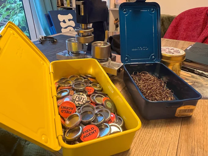 Button badges in a metal yellow box