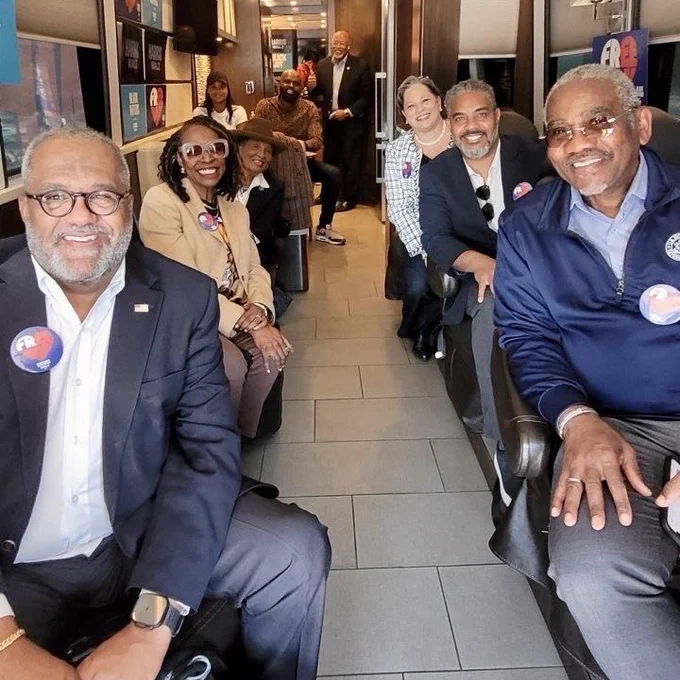 Photo of Reps. Troy Carter, Yvette Clarke, Alma Adams, Greg Meeks, Steven Horsford, Glenn Ivey, and me sitting on the bus.