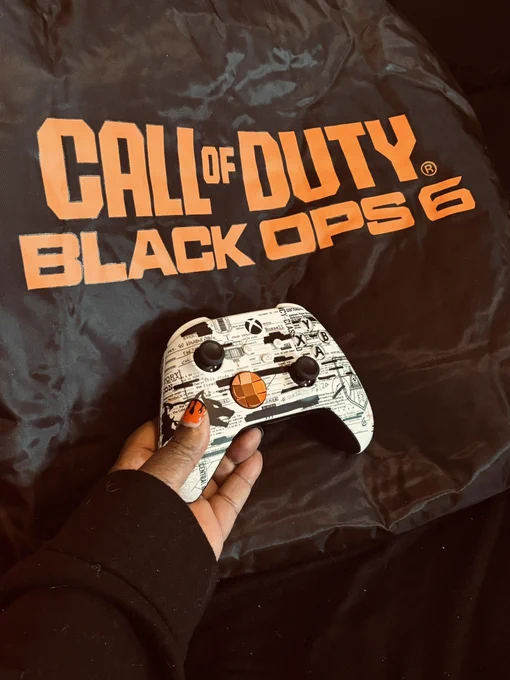 Saffista holding a Black Ops Xbox controller on top of a black Black Ops jacket