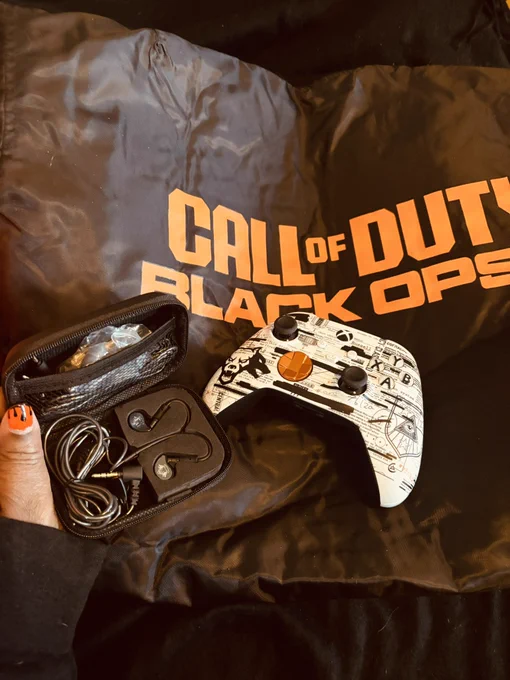Black Ops controller and earbuds on a black jacket