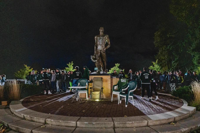 At night, members of the band surround Sparty with chairs set up nearby