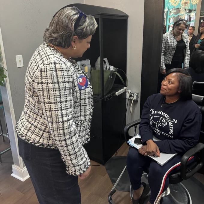 Photo of me speaking to a woman at the Fourth Ward Barber & Hairstyling Salon in Charlotte.