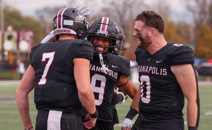 Members of the UIndy football team celebrate together.