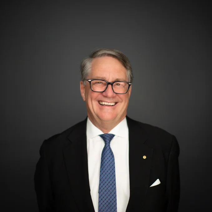 A headshot of The Hon Warwick Smith AO who is happily smiling