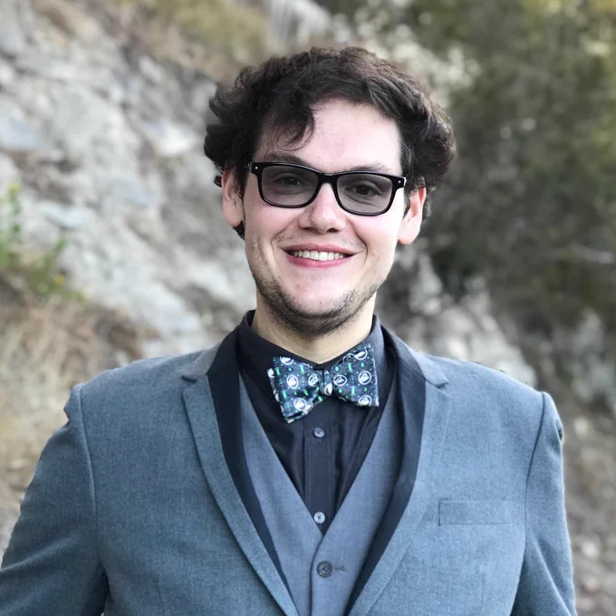 A headshot of Dr Paris Buttfield-Addison who is standing outside and happily smiling