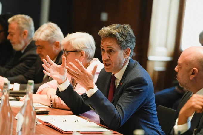 Energy Secretary Ed Miliband speaking at a pre-cop event at a table